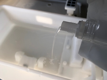 加湿器の水槽に次亜塩素酸水を入れている写真